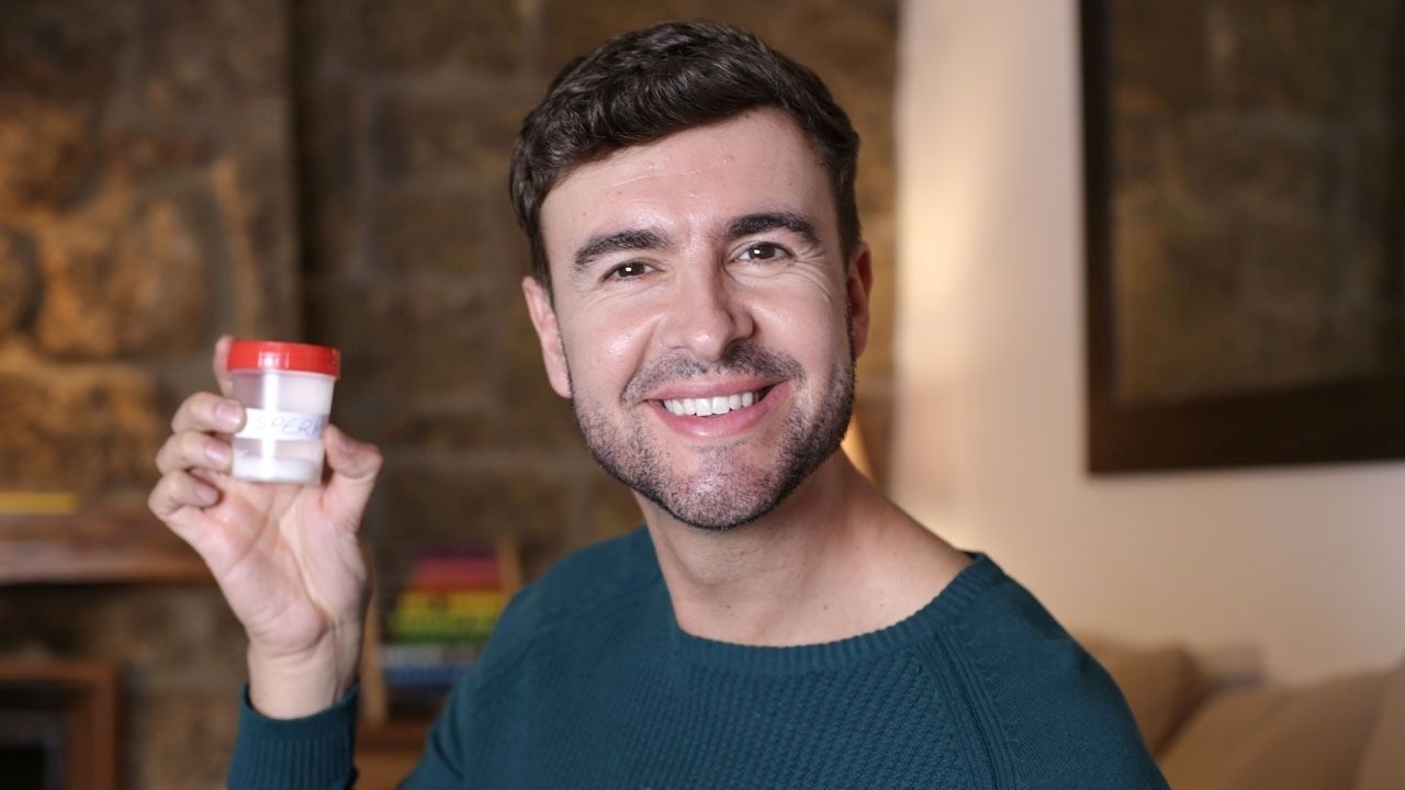 Samenspender sitzt im Behandlungsraum und füllt eine Spermaprobe in einen sterilen Becher