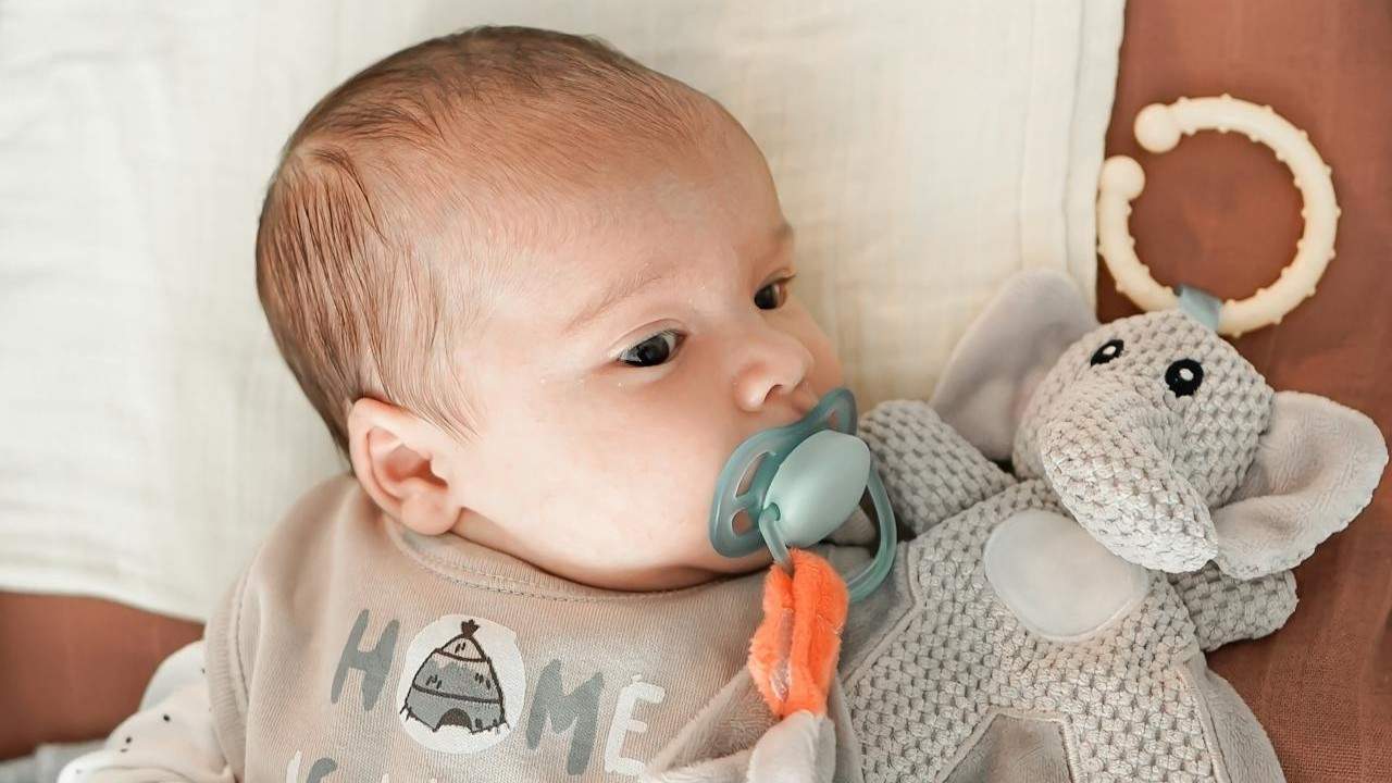 Baby mit Schnuller liegt ruhig im Kinderbett – symbolisches Bild für Kinderwunsch und Verantwortung